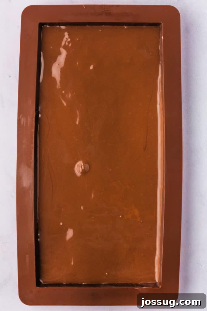 Golden Dubai Delight 13 Final chocolate layer spread smoothly in a silicone mold, sealing the Dubai Chocolate Bar.