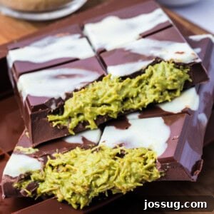 Square crop of two Dubai Chocolate Bars stacked on top of each other with visible green pistachio filling and white chocolate drizzle.