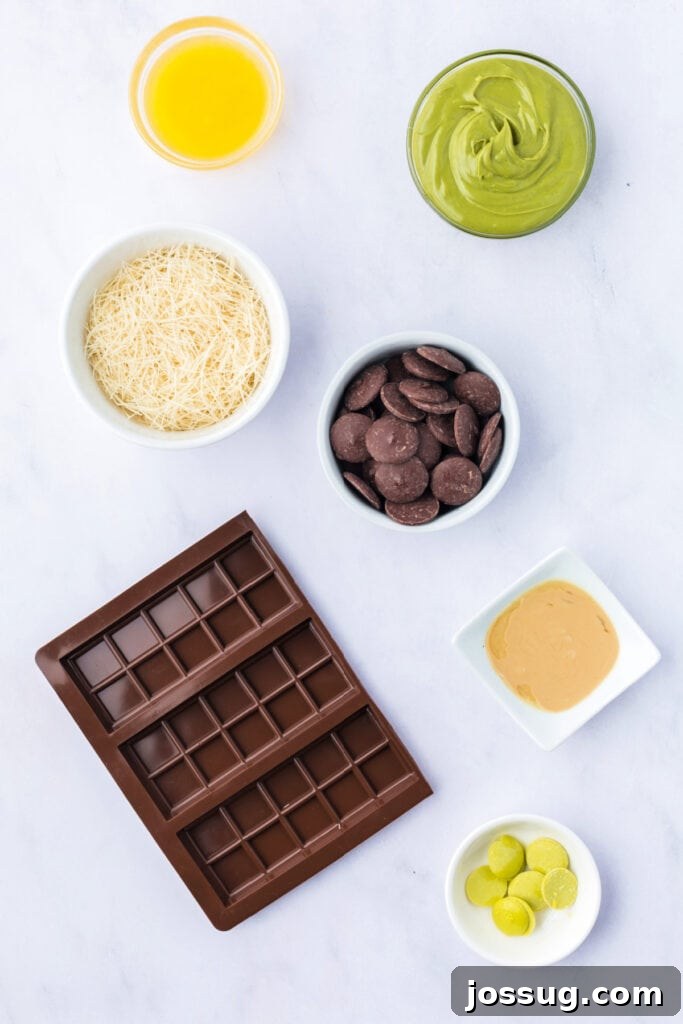 Golden Dubai Delight 3 Flat lay of ingredients for Dubai Chocolate Bar including kataifi pastry, pistachio butter, tahini, melting chocolate, melted butter, lime green candy melts, and a silicone chocolate bar mold.