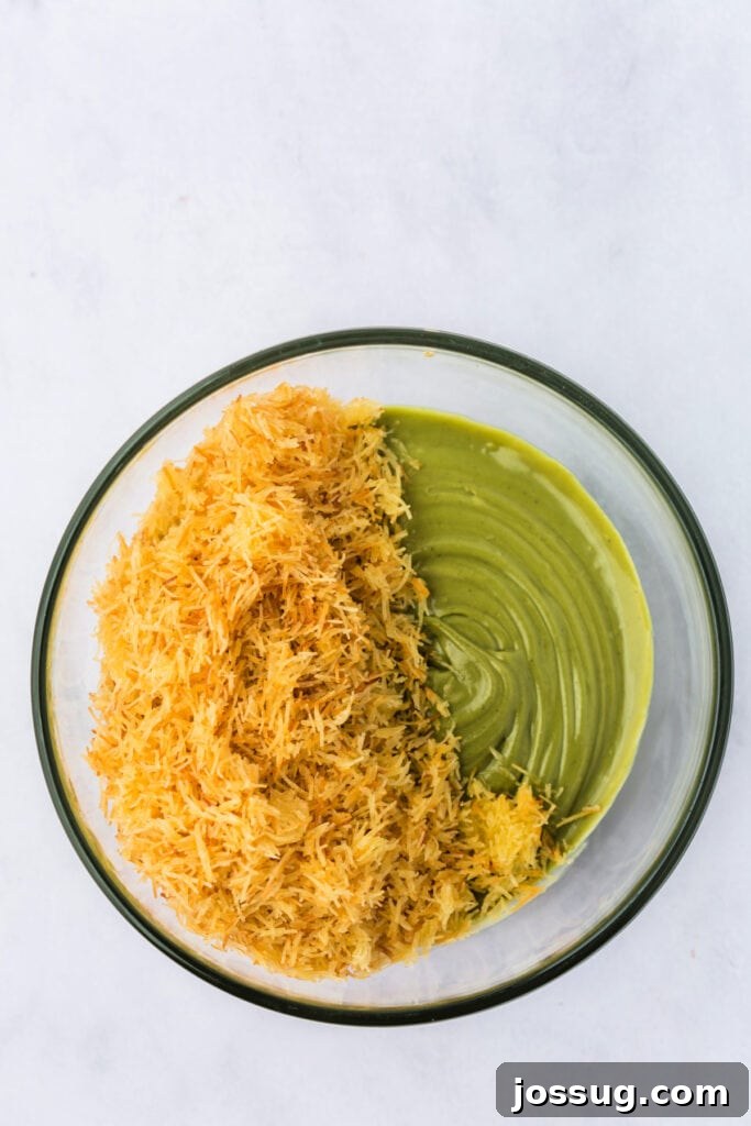 Golden Dubai Delight 8 Toasted kataifi pastry being folded into pistachio-tahini mixture in a glass mixing bowl.
