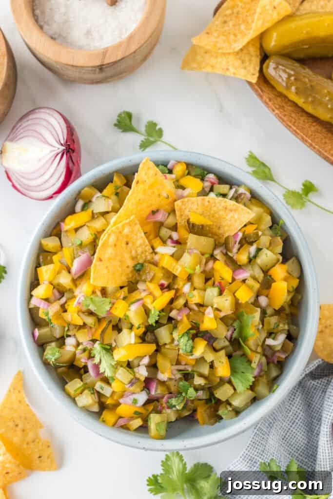 Overhead view of Pickle de Gallo served in a bowl with tortilla chips and garnished with fresh cilantro.