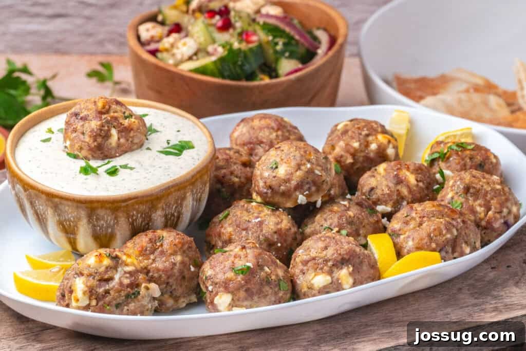 Platter of turkey feta meatballs with dipping sauce and Mediterranean salad in the background