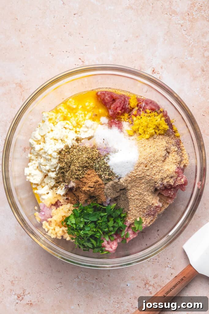 Bowl with ground turkey, feta, herbs, lemon zest, and other ingredients before mixing