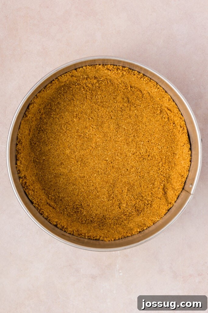 Pressed graham cracker crust in a springform pan, perfectly even and ready for the oven