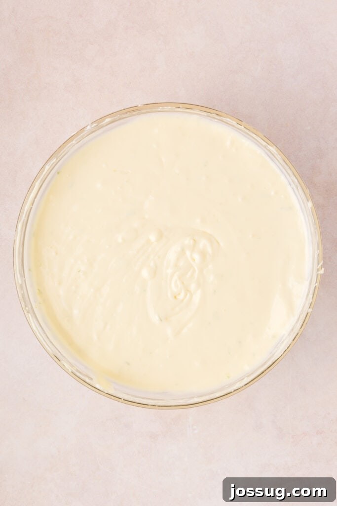 Fully blended Key Lime Cheesecake batter in a mixing bowl, vibrant and ready to pour