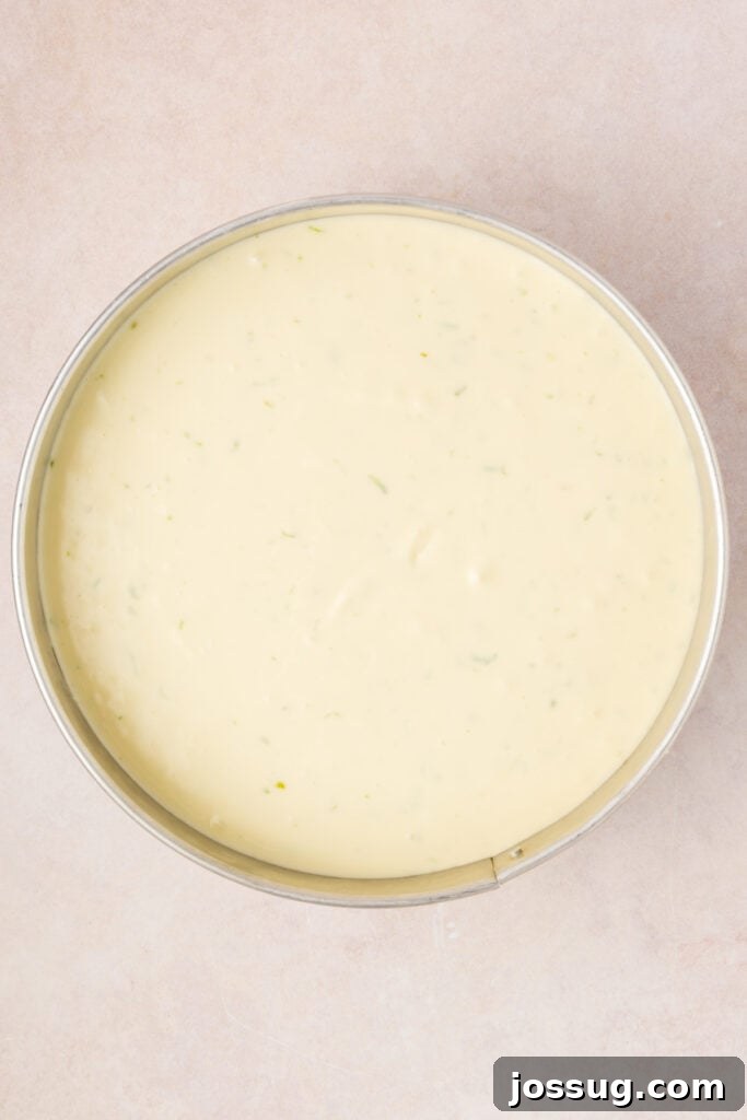 Key Lime Cheesecake batter poured evenly into the baked crust in a springform pan, ready for the water bath