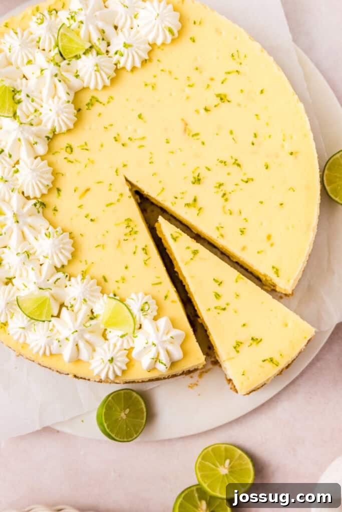 Baked Key Lime Cheesecake fresh out of the oven, lightly golden and set, topped with whipped cream and lime zest for garnish