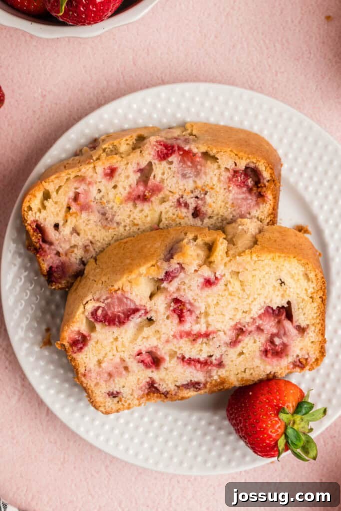 Sweet Strawberry Loaf 16 A close-up, tempting view of two slices of freshly baked strawberry bread, revealing the juicy pieces of berries distributed perfectly within the moist, tender crumb.
