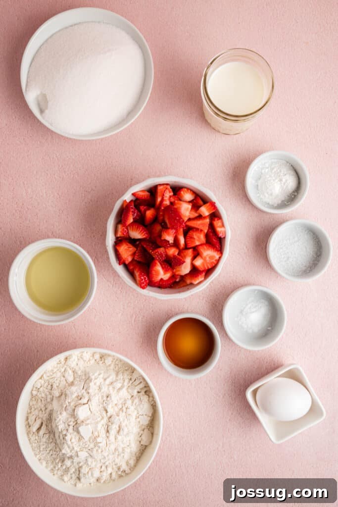 Sweet Strawberry Loaf 3 An overhead shot showcasing all the essential ingredients for strawberry bread neatly arranged on a vibrant pink background, including flour, sugar, fresh strawberries, milk, oil, and eggs.