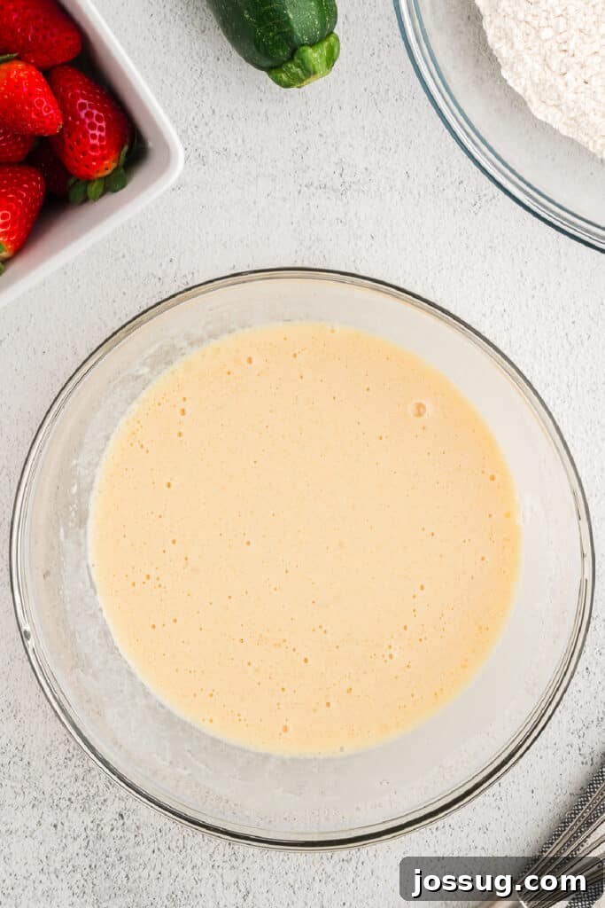 The wet ingredients, now whisked smooth and pale yellow, waiting for the sugars to be added.