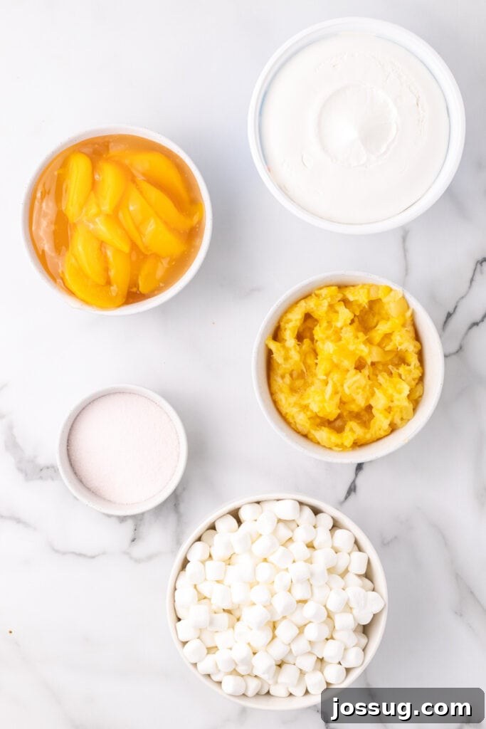 Overhead view of ingredients for peach fluff salad in bowls on a marble surface, ready for mixing.