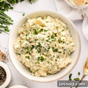 Closeup of herbed egg salad in a bowl, showcasing its creamy texture and fresh ingredients.