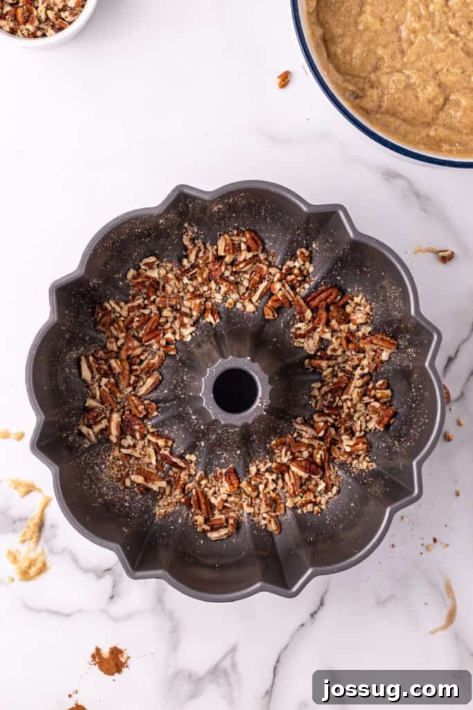 Tropical Spiced Bundt Cake 6 Toasted pecans lining the bottom of a Bundt pan before the cake batter is poured in.