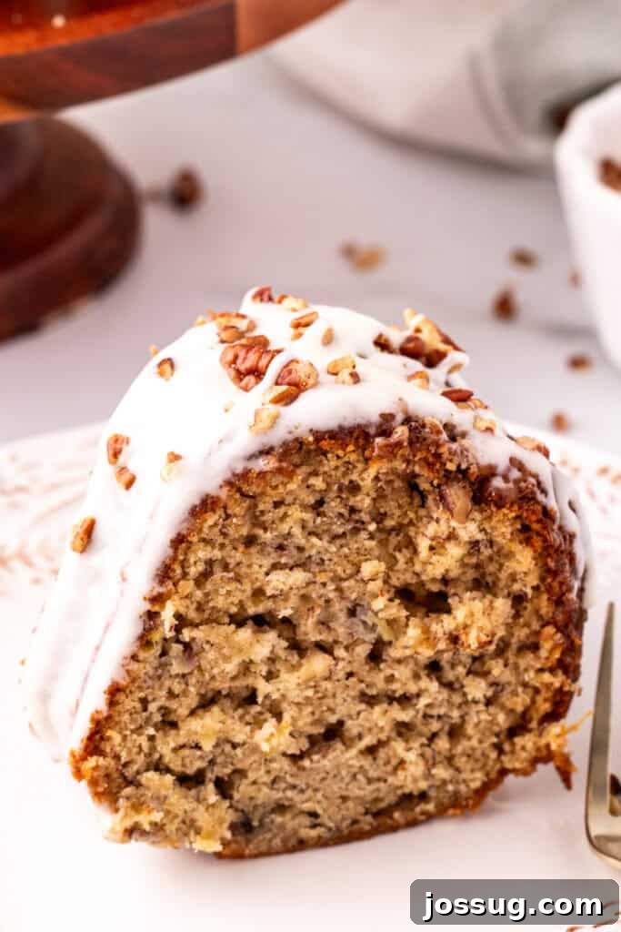 Tropical Spiced Bundt Cake 10 A delicious slice of Hummingbird Bundt Cake on a white plate, showcasing its moist texture and glaze.