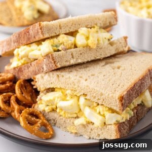 A close-up of a Million Dollar Egg Salad sandwich, showcasing the filling and toppings.