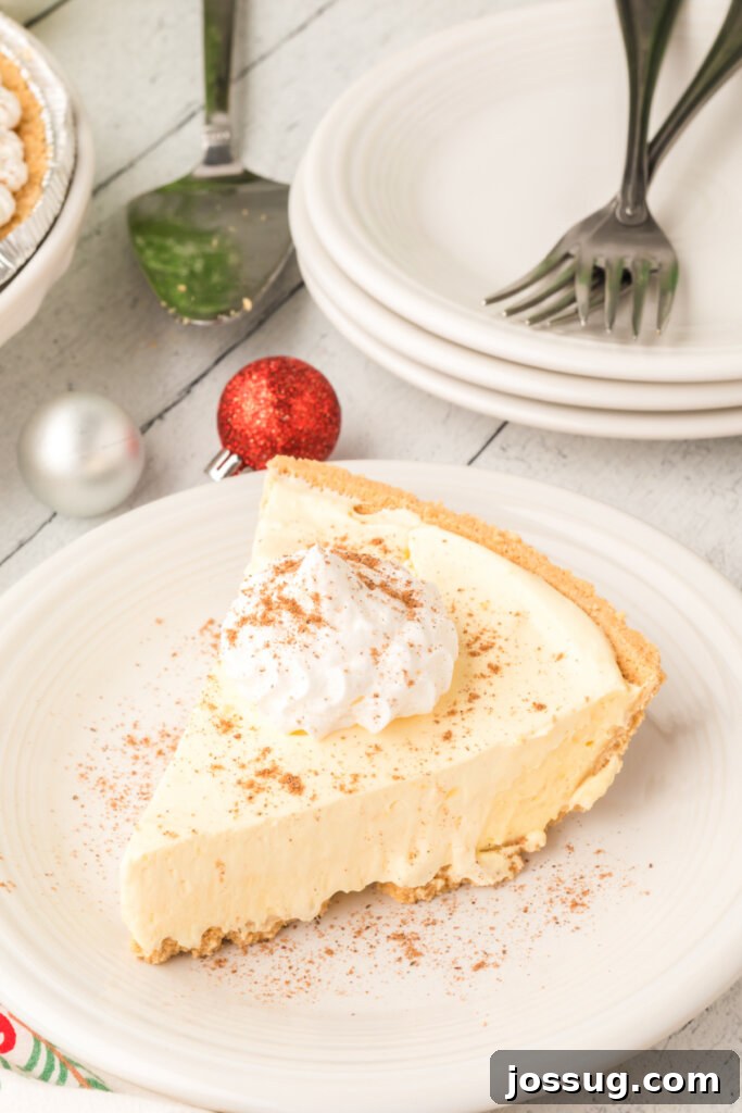 Dreamy No-Bake Eggnog Pie 2 Slice of creamy No-Bake Eggnog Pie on a white plate, ready to be enjoyed during the holidays.