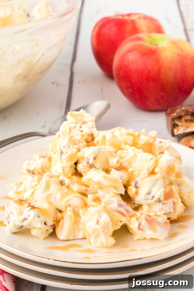 Caramel Apple Snickers Salad on a plate, showcasing its delicious layers of apples, Snickers, and creamy dressing with caramel drizzle.