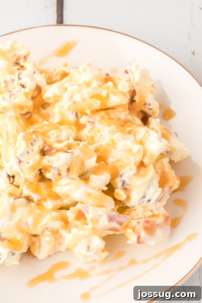 A close-up view of Caramel Apple Snickers Salad on a plate, showing the rich caramel drizzle and perfectly chopped ingredients.