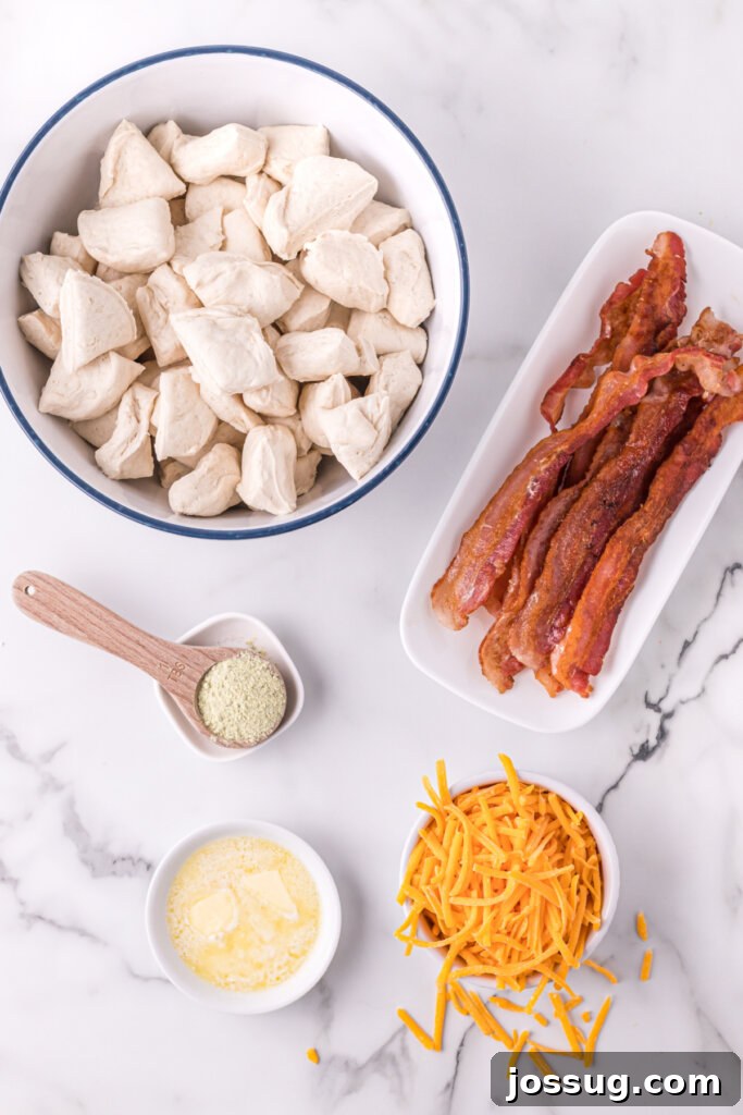 Loaded Bacon Cheddar Ranch Bread 3 ingredients laid out to make cheddar bacon ranch pull apart rolls, including biscuits, bacon, cheese, and ranch mix