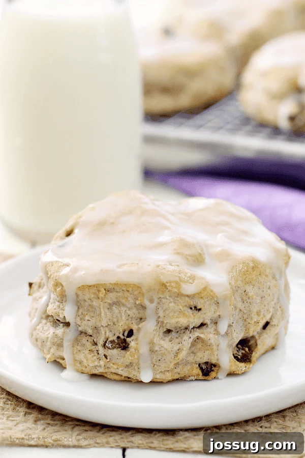 Homemade Cinnamon Raisin Comfort Biscuits 2 Cinnamon Raisin Biscuit on a white plate with a glass of milk, inviting a cozy breakfast.
