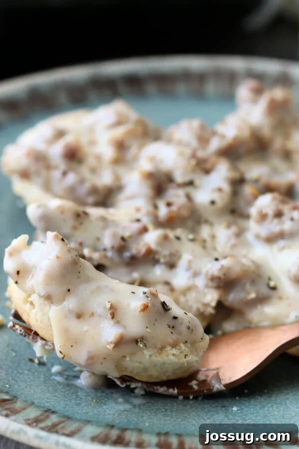 Hearty Homestyle Sausage Gravy 2 sausage gravy and biscuits on blueish-teal plate, ready to be enjoyed