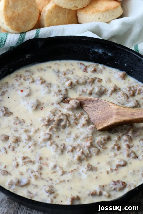 Hearty Homestyle Sausage Gravy 7 Thickened sausage gravy simmering in a skillet, ready to serve