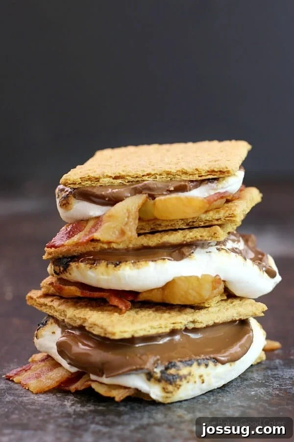 Perfectly stacked Bacon S'mores on a rustic cutting board, showcasing crispy bacon, melted chocolate, and golden marshmallows between graham crackers.