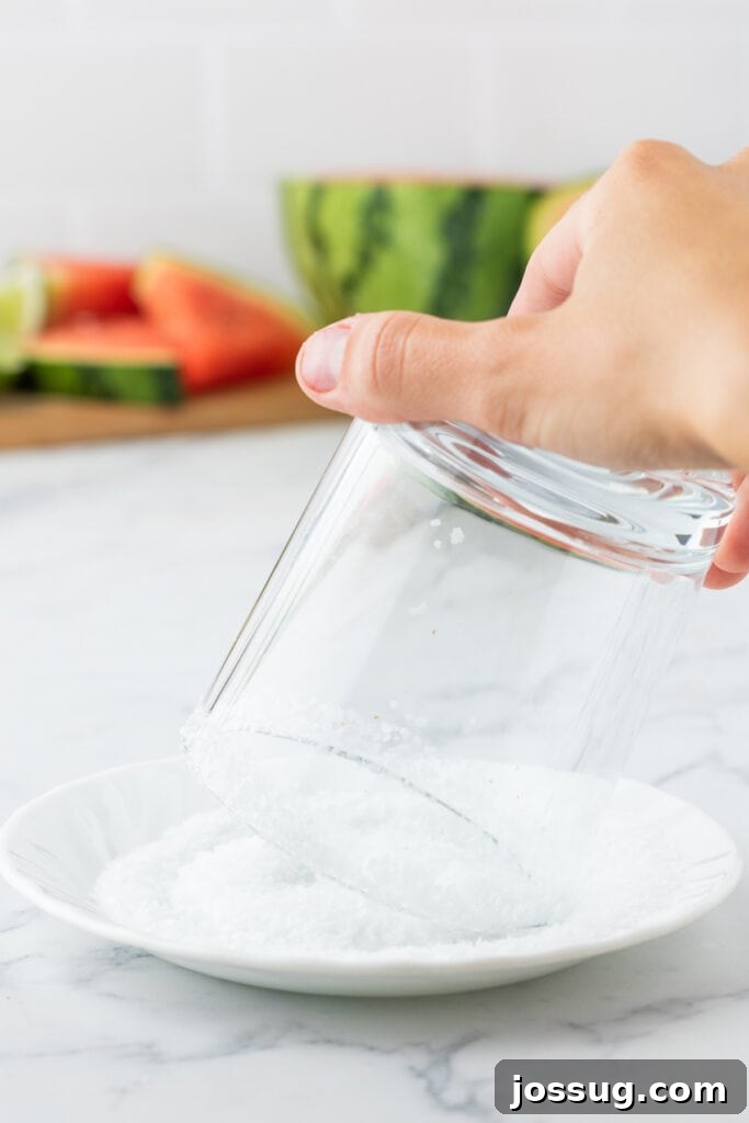 Crimson Wave Margarita 5 Hand dipping a clear glass with a moist rim into coarse margarita salt for a classic finish