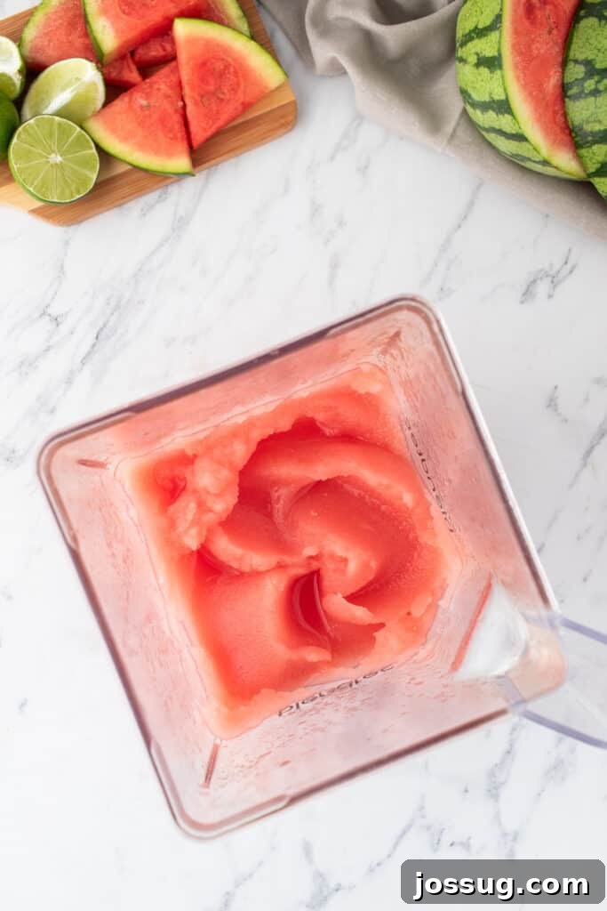 Crimson Wave Margarita 9 Top view of a blender filled with thick, rich frozen watermelon margarita mixture, indicating a perfect slushy consistency