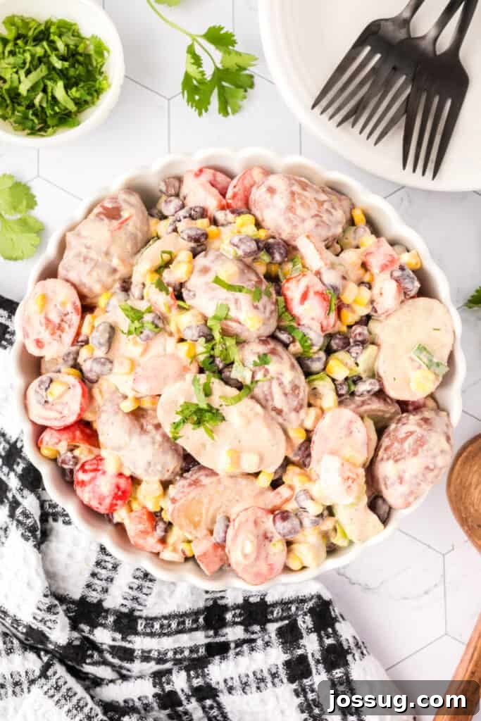 Southwest Potato Salad in a white scalloped dish, garnished with fresh cilantro.