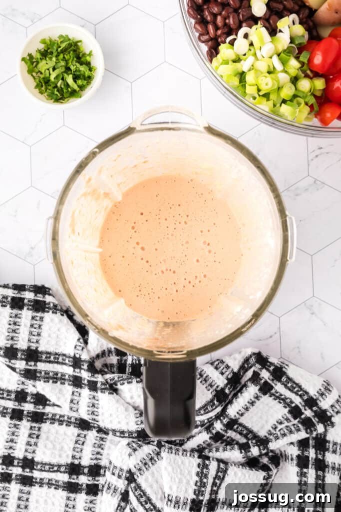 Blender showing fully blended creamy Southwest salad dressing.