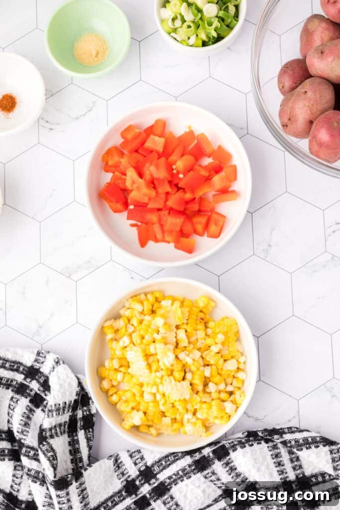 Bowls of chopped roasted red pepper and corn kernels displayed side by side.