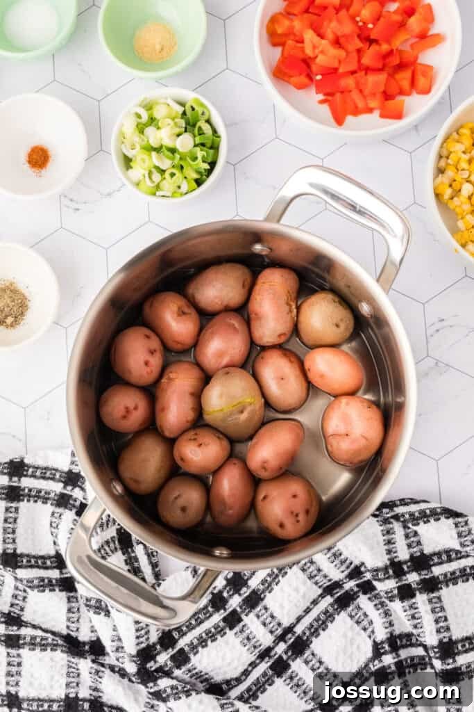 Boiled red potatoes in a saucepan after cooking, skins slightly wrinkled.