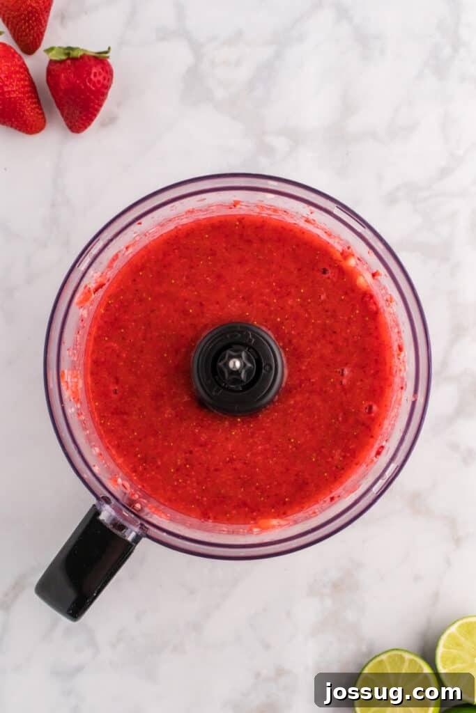Blush Burst Cooler 5 Blended strawberry purée in a food processor, smooth and vibrant red, indicating readiness for the next step.