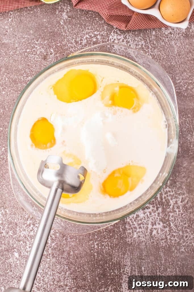 Caramel Flan Bites 5 Glass mixing bowl filled with eggs, cream, and cream cheese, ready to blend for caramel flan.