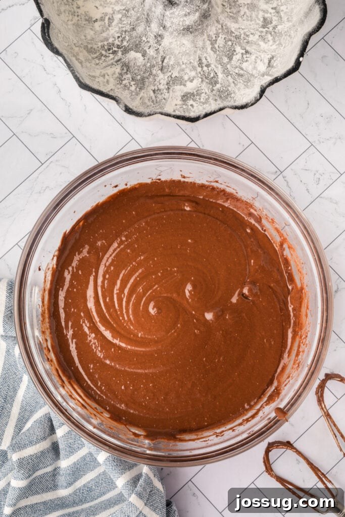 Decadent Kahlua Chocolate Bundt 7 The chocolate cake batter, perfectly mixed to a smooth and consistent texture, is now prepared to be poured into the greased Bundt pan.
