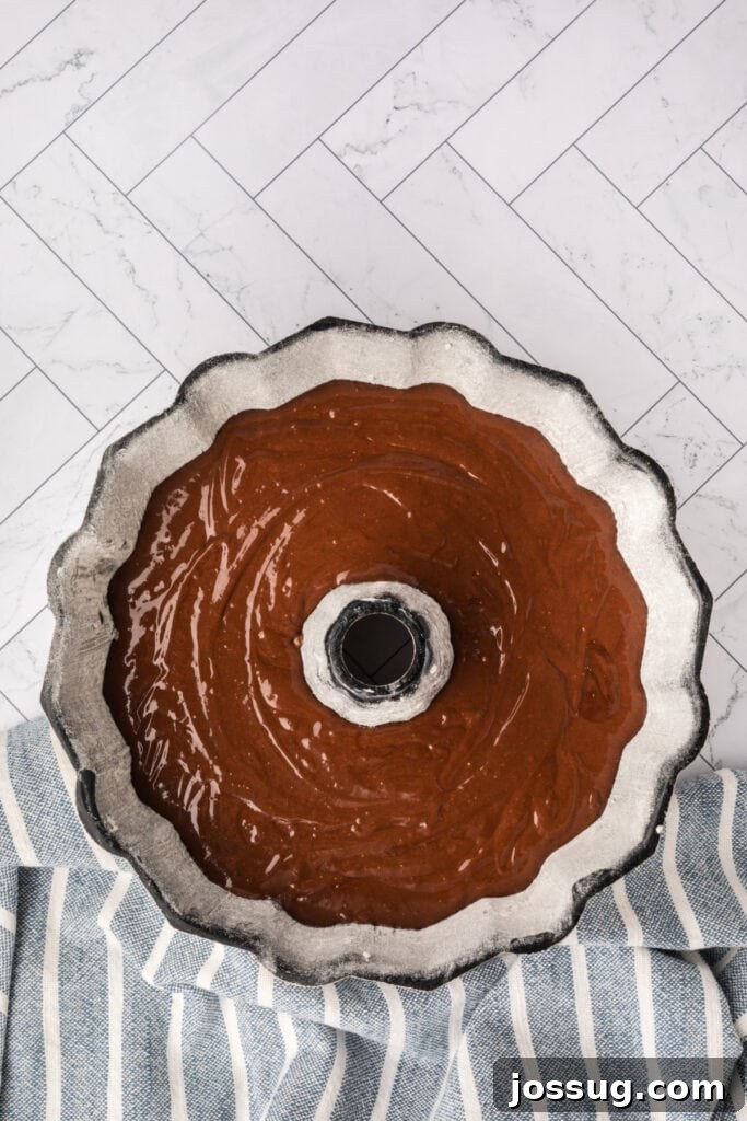 Decadent Kahlua Chocolate Bundt 8 Lustrous chocolate cake batter has been carefully poured into the prepared Bundt pan, ensuring an even distribution for uniform baking.