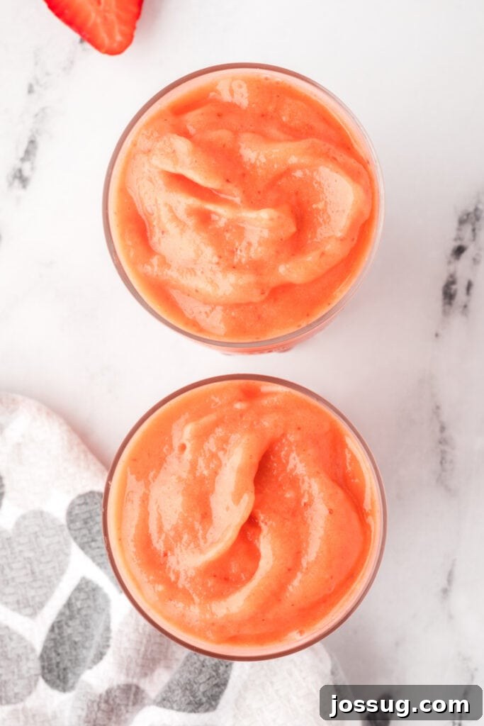 Tropical Ombre Smoothie 6 Overhead view of two glasses filled with colorful sunrise sunset smoothies, garnished and ready to enjoy.