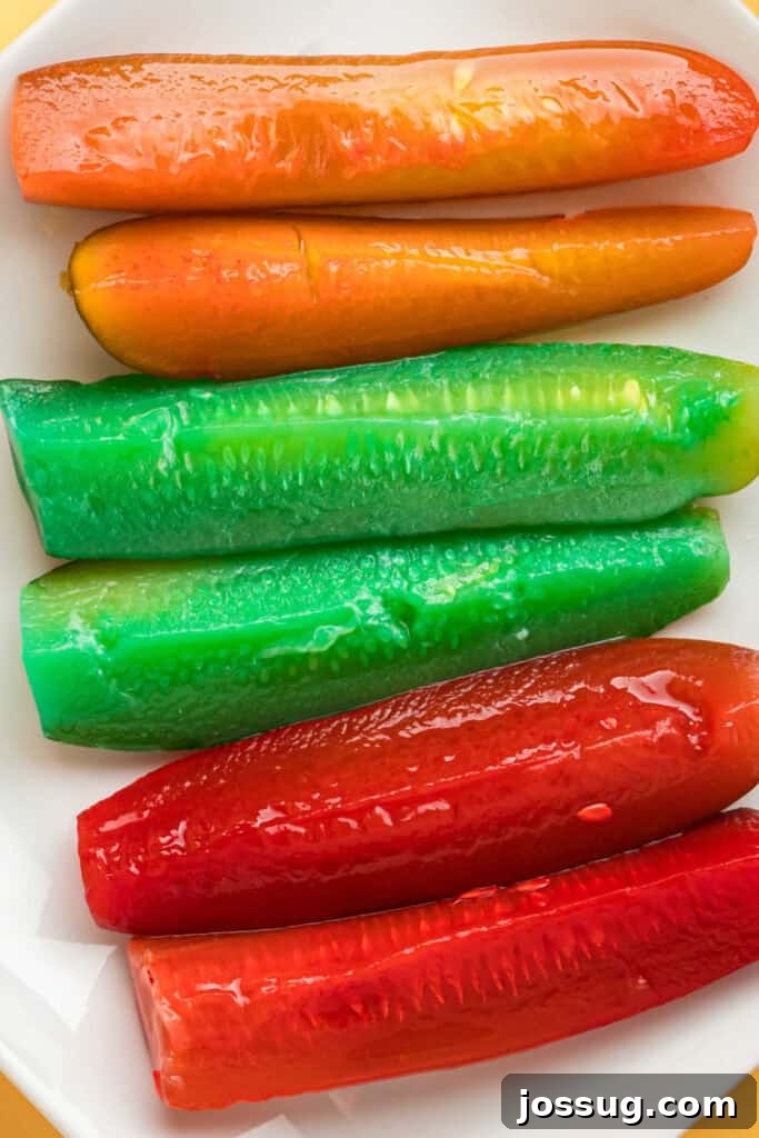 Sweet & Sour Zingers 2 Overhead view of assorted Kool-Aid pickles displayed on a white plate, showcasing vibrant red, blue, and green colors.