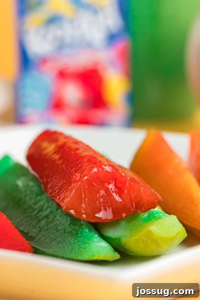 Sweet & Sour Zingers 11 A close-up view of brightly colored Kool-Aid pickles (red, blue, green) artfully arranged on a pristine white plate, ready to be served.