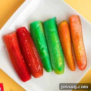 Sweet & Sour Zingers 13 Square image of colorful Kool-Aid pickles arranged neatly on a white plate, highlighting their vibrant appearance.