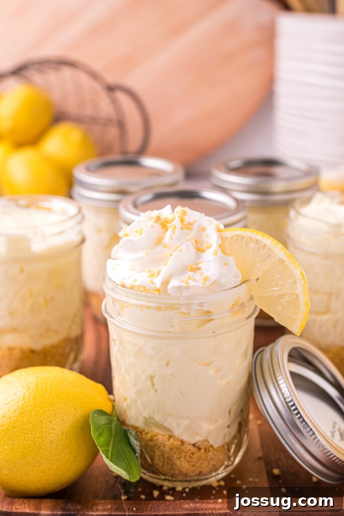 Zesty No-Bake Lemon Cheesecake Jars 3 Two lemon cheesecake jars artfully arranged on a rustic wooden board, ready to be enjoyed