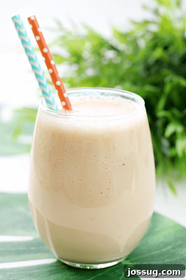 A refreshing Jungle Cooler served in a clear glass with two colorful straws, ready to be enjoyed.