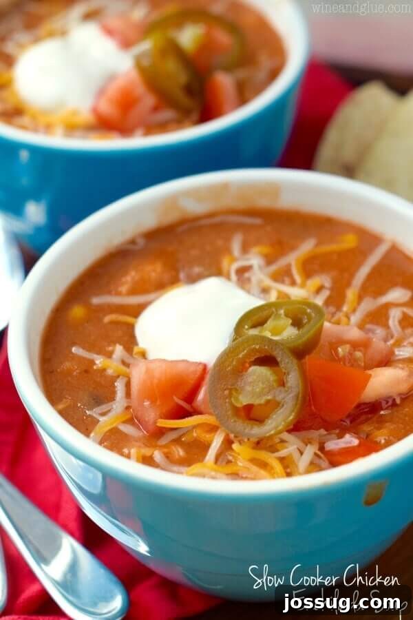 30 Set-and-Forget Slow Cooker Meals 3 Slow cooker chicken enchilada soup served in a vibrant blue bowl, garnished with fresh cilantro and a dollop of sour cream.
