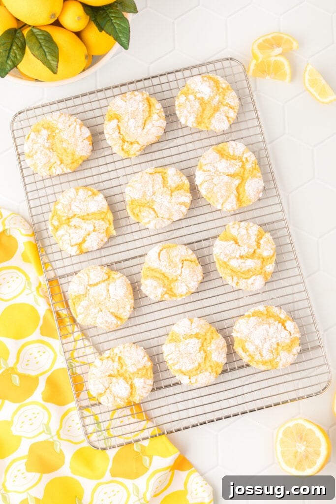 Sunshine Lemon Crinkles 3 Freshly baked lemon cookies cooling on a wire rack, showcasing their beautiful crinkled texture.
