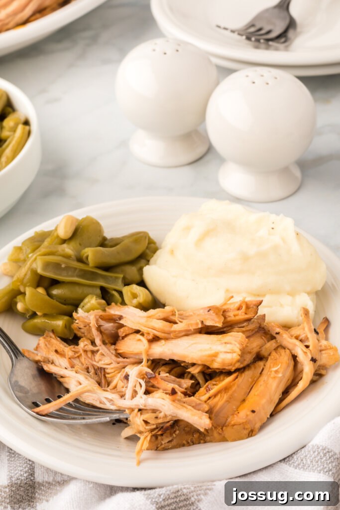 Melt-in-Your-Mouth Slow Cooker Pork 4 A dinner plate featuring a hearty portion of slow cooker pork roast, fluffy mashed potatoes, and vibrant green beans.
