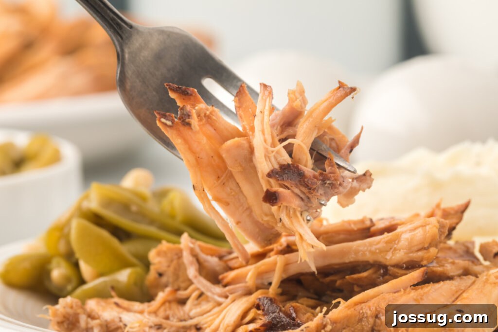 Melt-in-Your-Mouth Slow Cooker Pork 5 A succulent piece of slow cooker pork roast on a fork, showcasing its tender, juicy texture and readiness for serving.