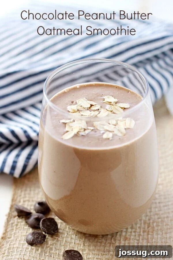 A tall glass filled with a creamy Chocolate Peanut Butter Oatmeal Smoothie, garnished for freshness.