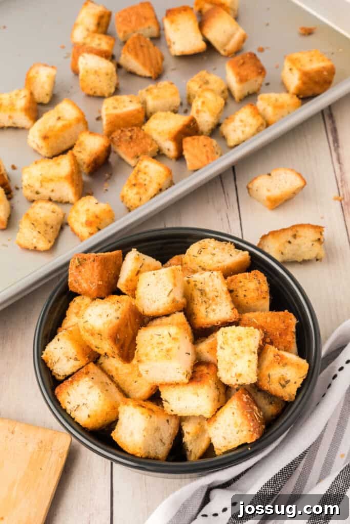 Golden Garlic Parmesan Croutons 2 Homemade Garlic Parmesan Croutons in a bowl and on a baking sheet, ready to enhance any dish.
