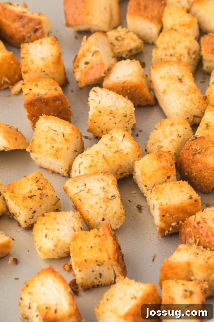 Golden Garlic Parmesan Croutons 3 Freshly made homemade croutons cooling on a baking sheet after being toasted to golden perfection.